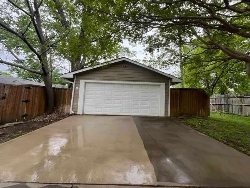 Driveway half cleaned, showing the line between washed and unwashed concrete